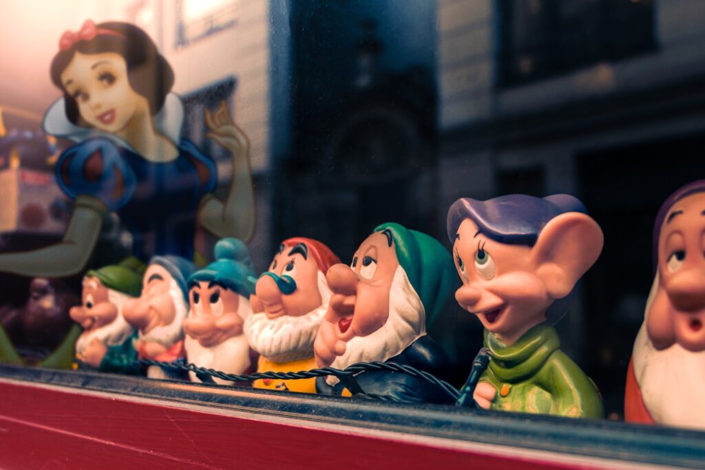 a row of snow white figurines sitting on top of a shelf