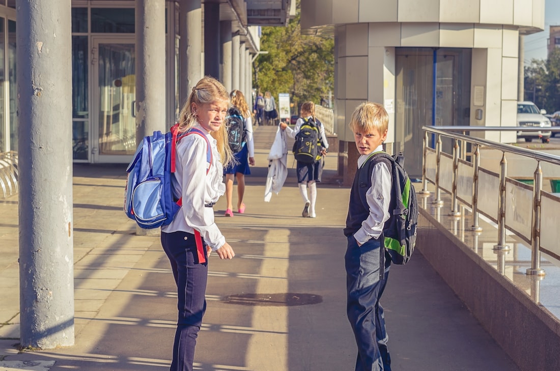 Deux enfants marchant vers l'école avec leur cartable sur le dos